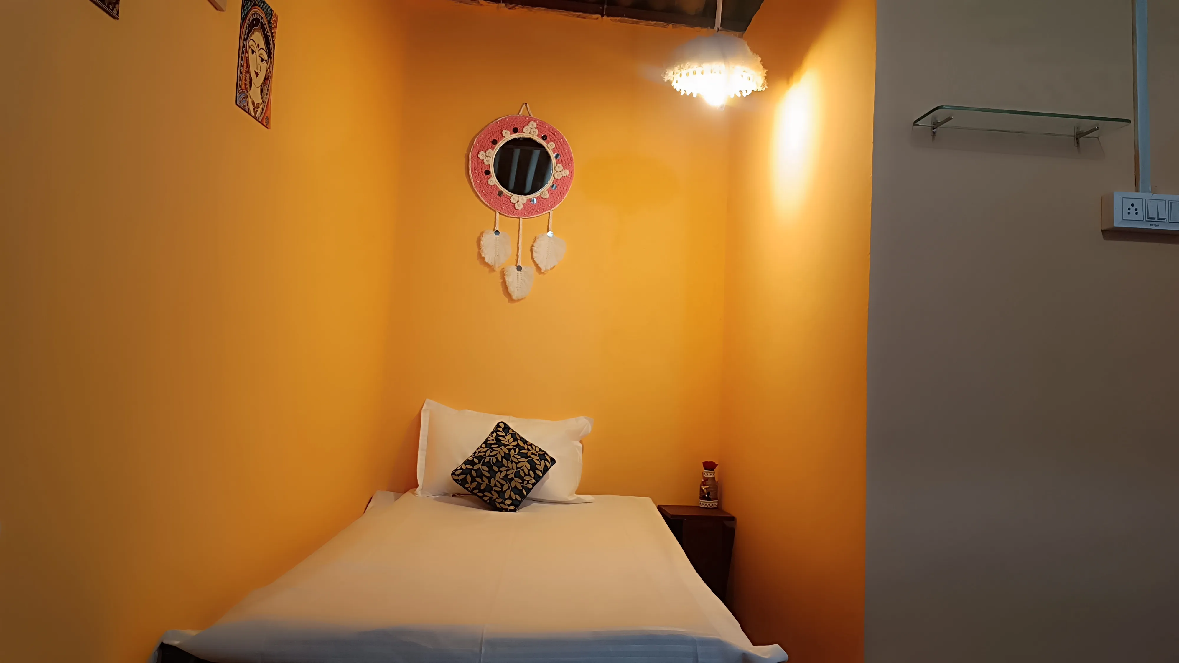 A charpai bed with white linen in the single hut.