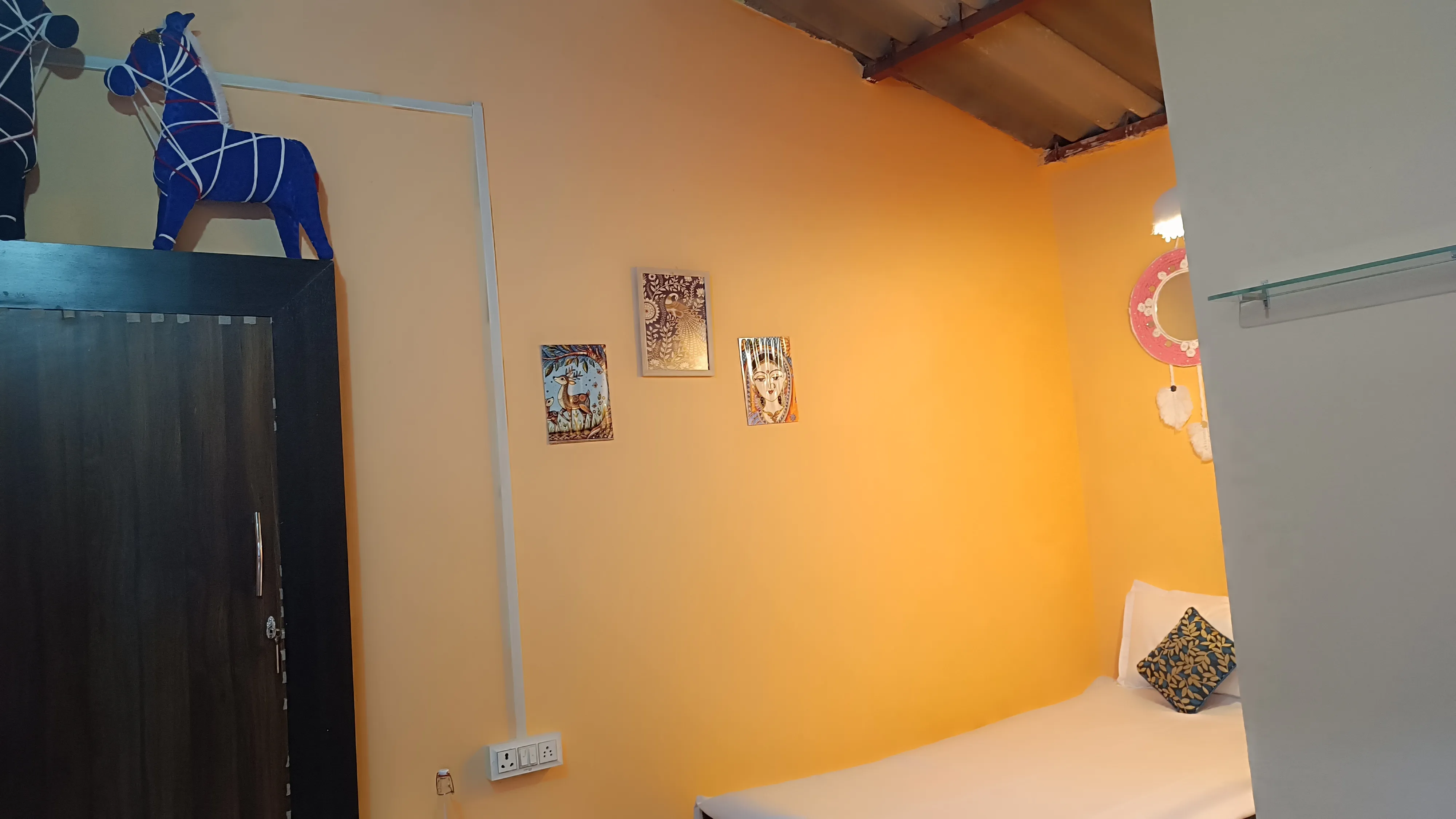 The single hut seen from the doorway, with wall art and a wardrobe.