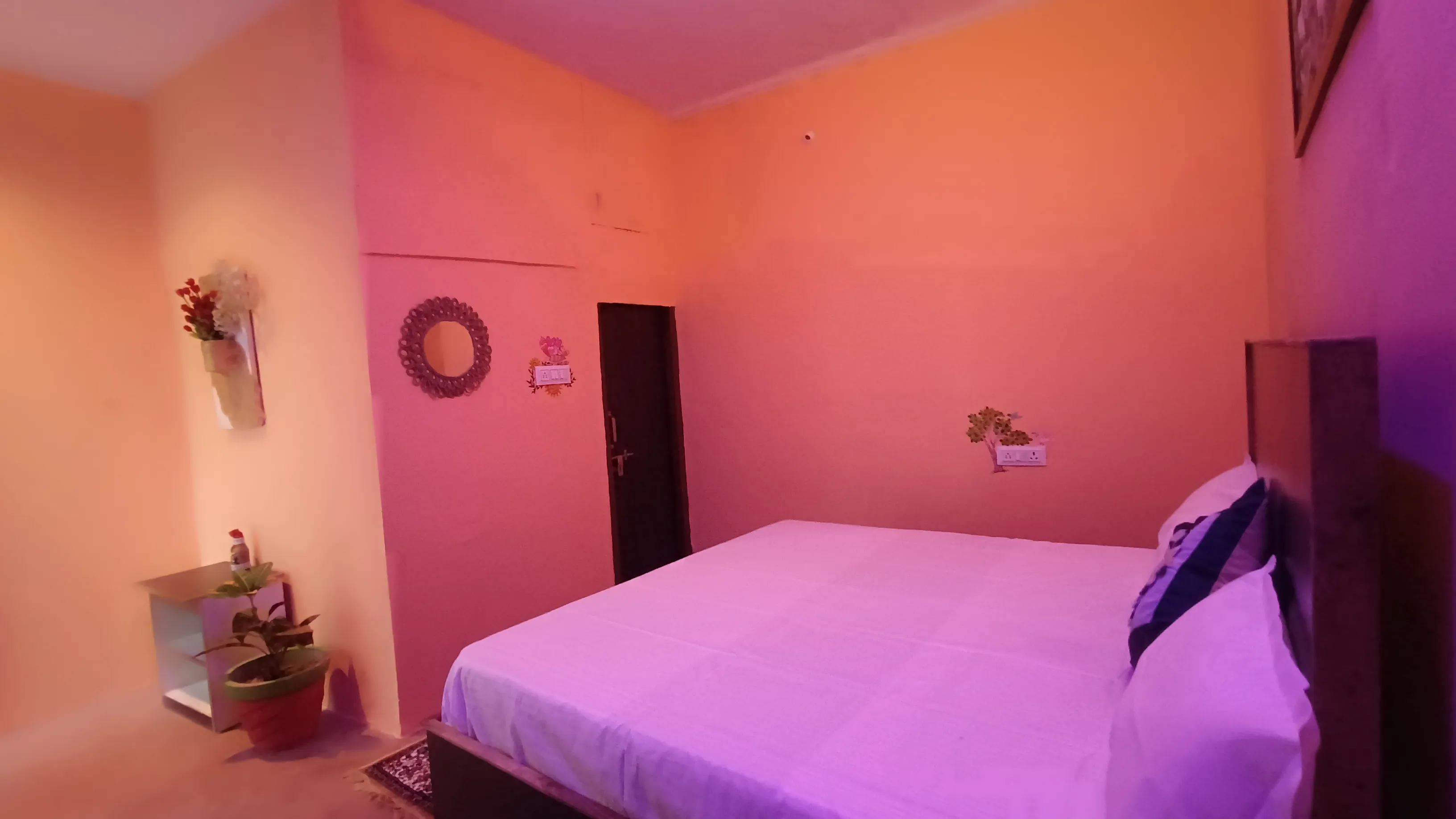 The bed and entry door, viewed from the opposite side of the room.