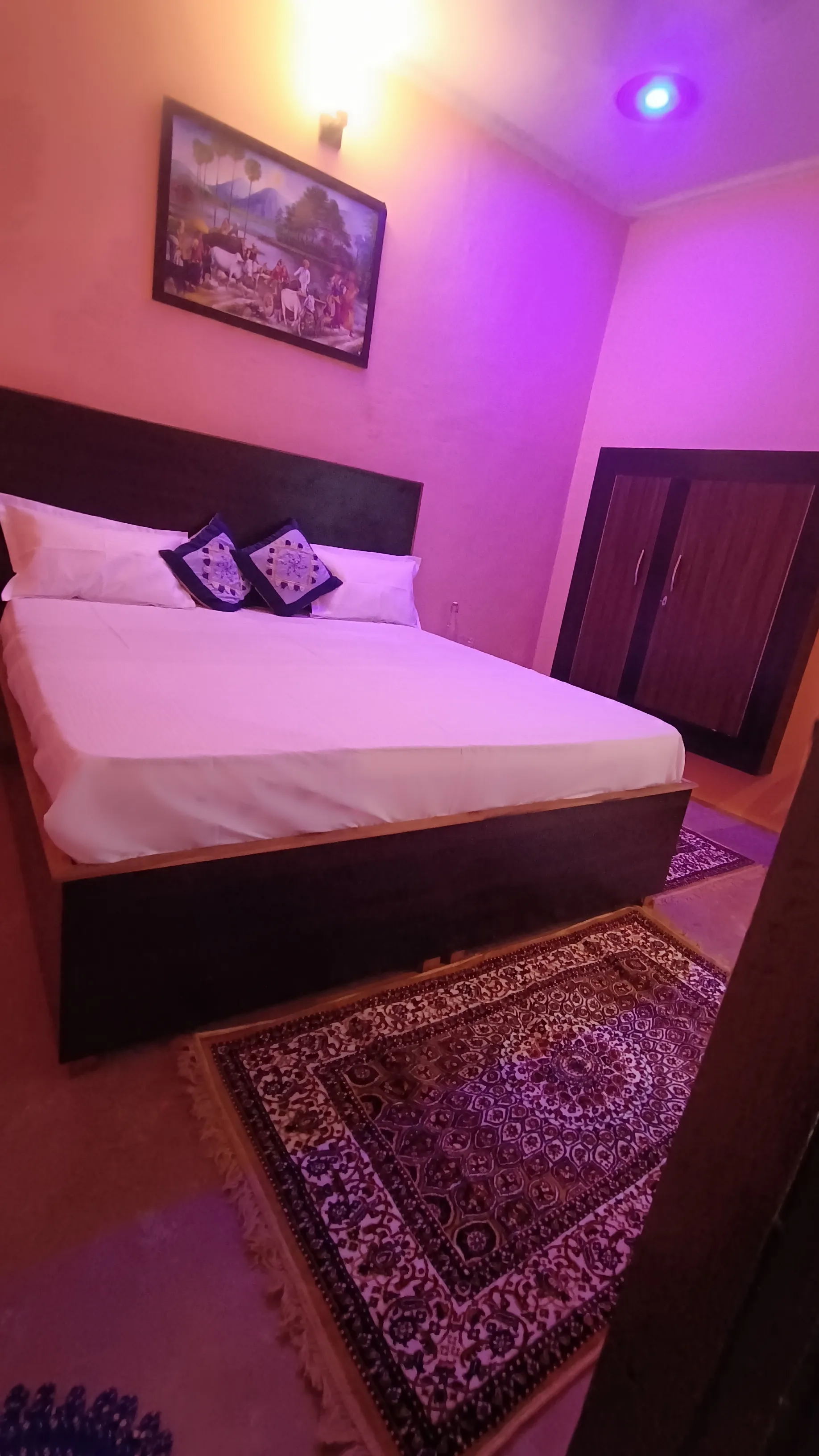 A closer angle of the standard room bed and wardrobe.